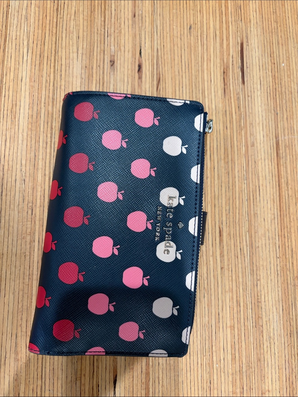 kate spade navy wallet with pink, red, and white apple motif